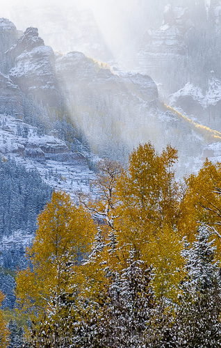 Sun breaking through clouds on snowy autumn landscape in the Uncompahgre Range, Owl Creek Pass, Colorado